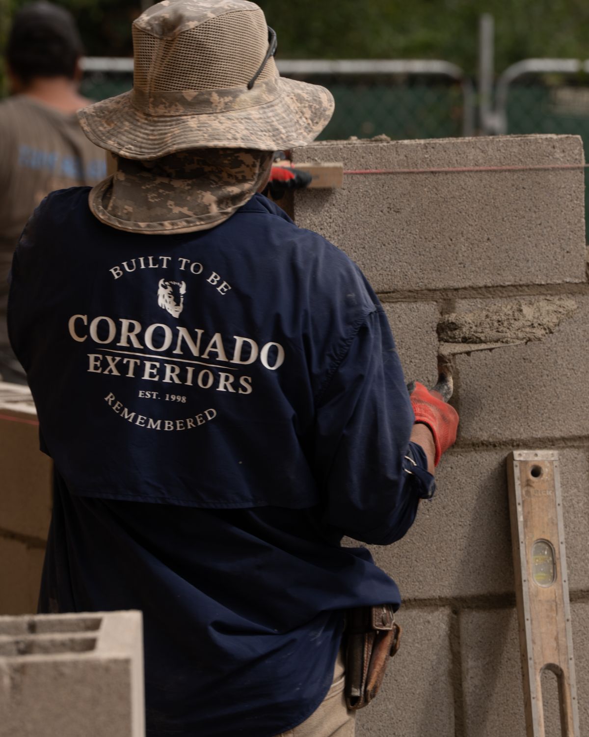 Buttering mortar joints on a concrete block wall
