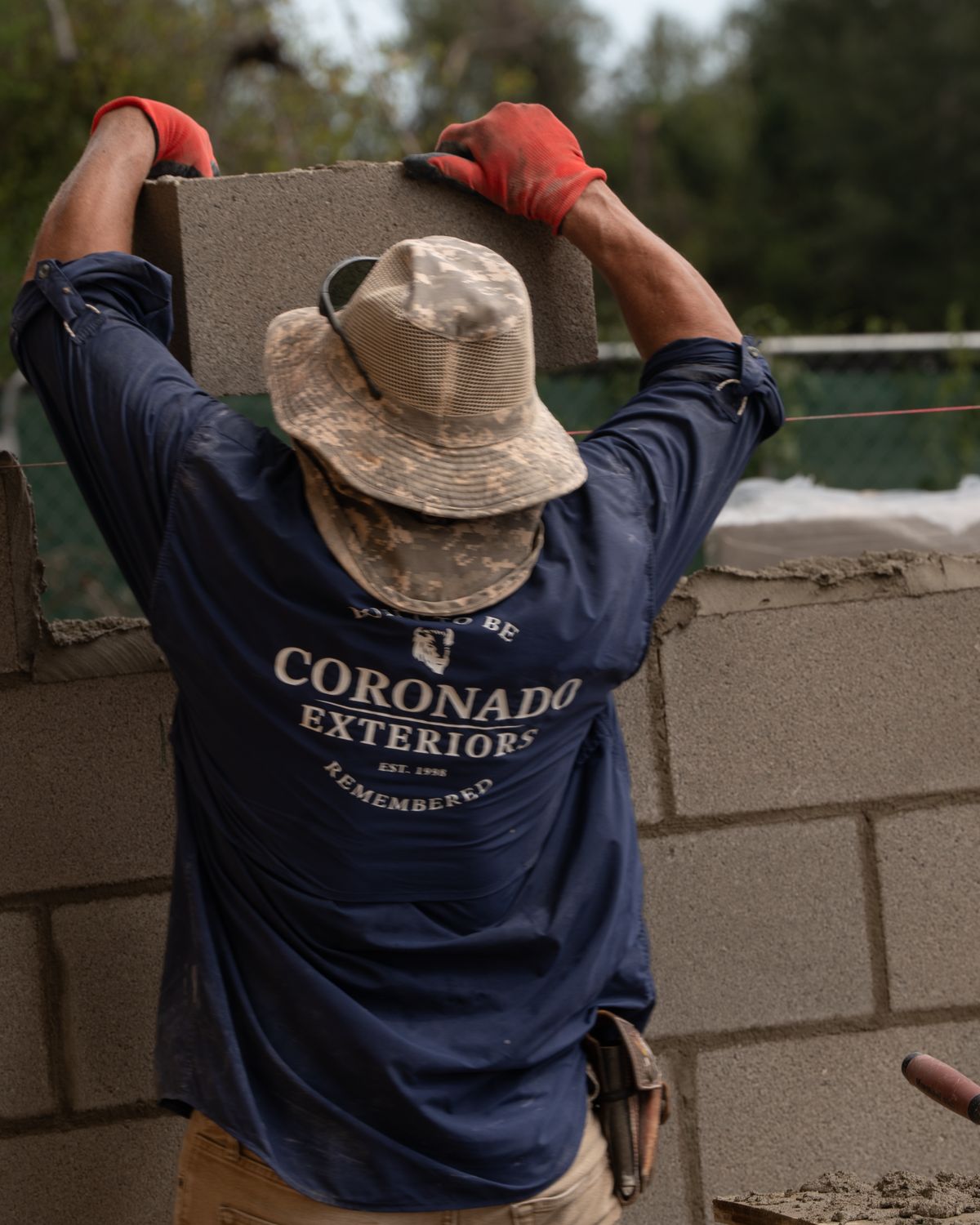 Coronado Exteriors mason setting a CMU block
